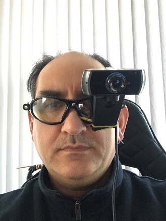 a man with a webcam attached to his glasses, covering one eye