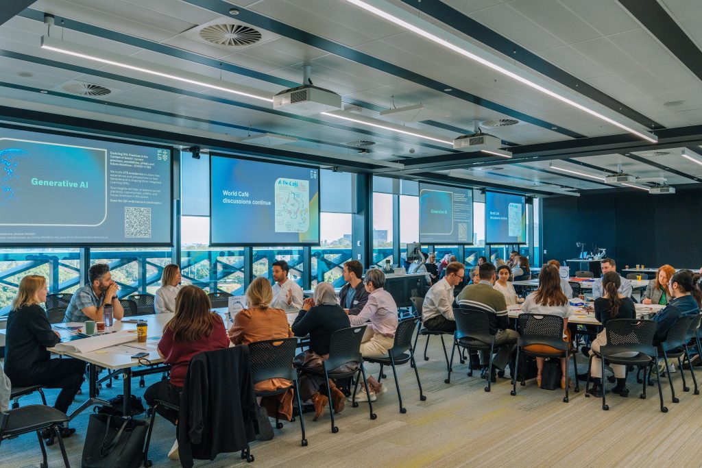 A wide angle shot of the event with 2 tables and people sitting
