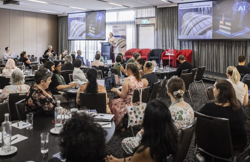 Audience at tables listening to Lucy Bryant's presentation