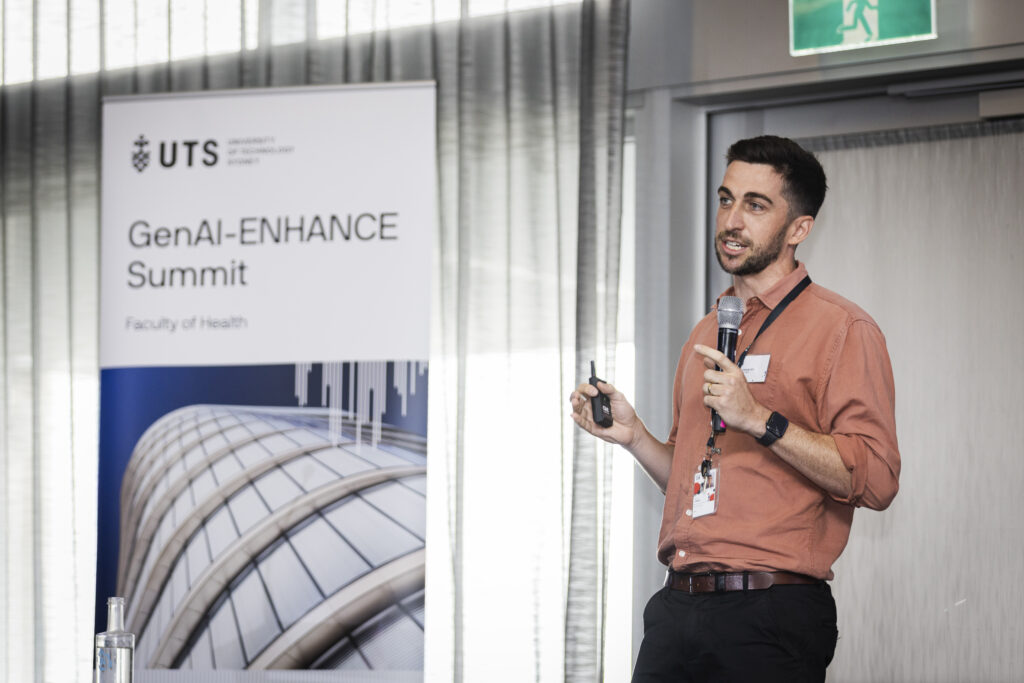 Josh Pate presents in front of GenAI-ENHANCE sign